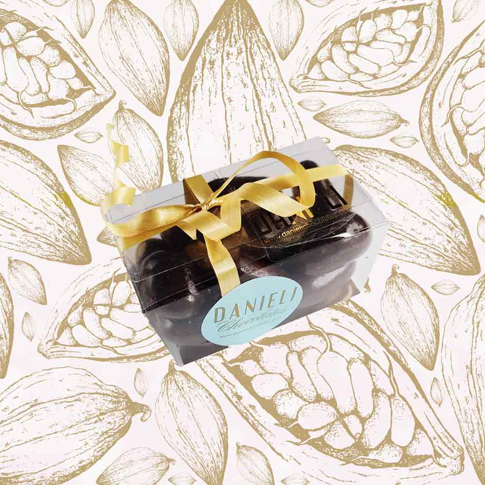 side view of a gift box of Danieli dark chocolate brazils on a cacao background