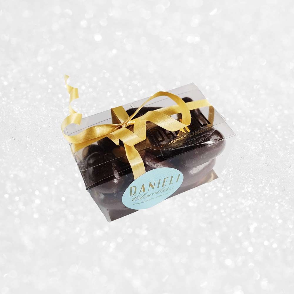 side view of a gift box of Danieli dark chocolate brazils on a snowy background