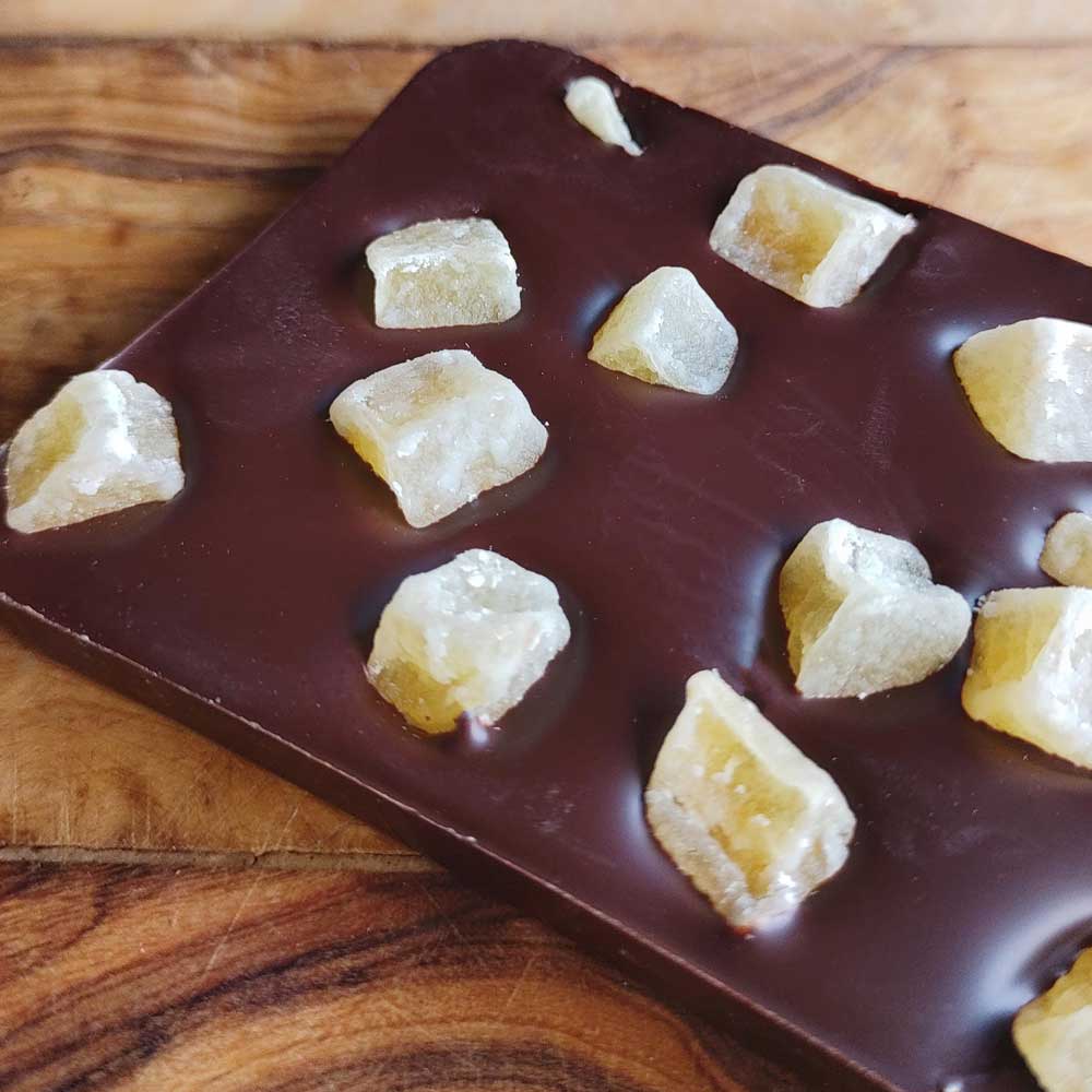 close up of dark chocolate ginger bar on a wooden board