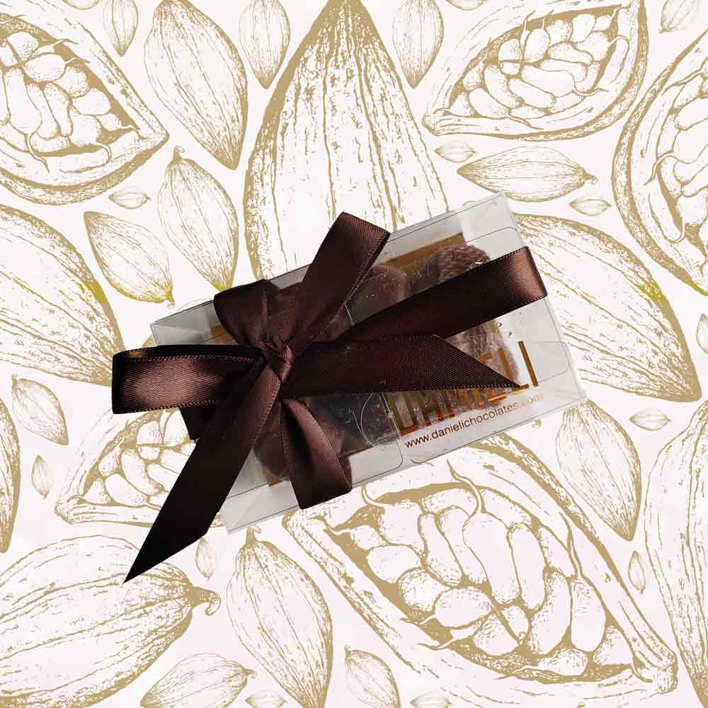 top view of a gift box of Danieli dark chocolate gingers on a cacao background