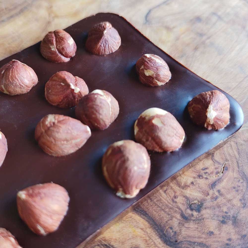 close up of Danieli dark chocolate hazelnut bar on a wooden board