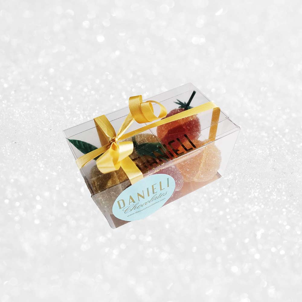 side view of a presentation box of Danieli fruit jellies on a snowy background
