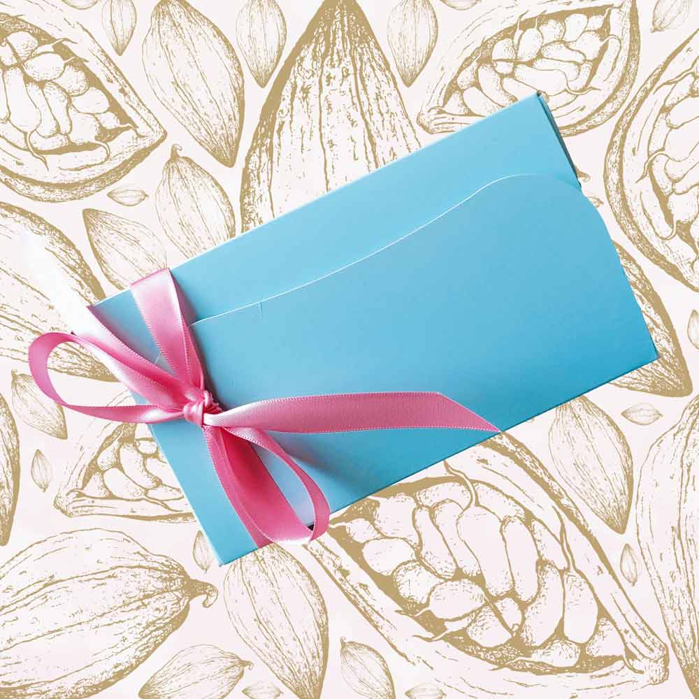 Top view of a large ballotin of chocolates for Mothers Day with a pink ribbon