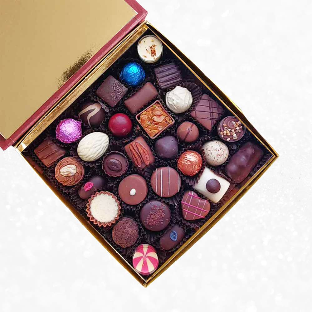 inside view of Danieli chocolates for Christmas luxury red box large with a gold ribbon on a snowy background