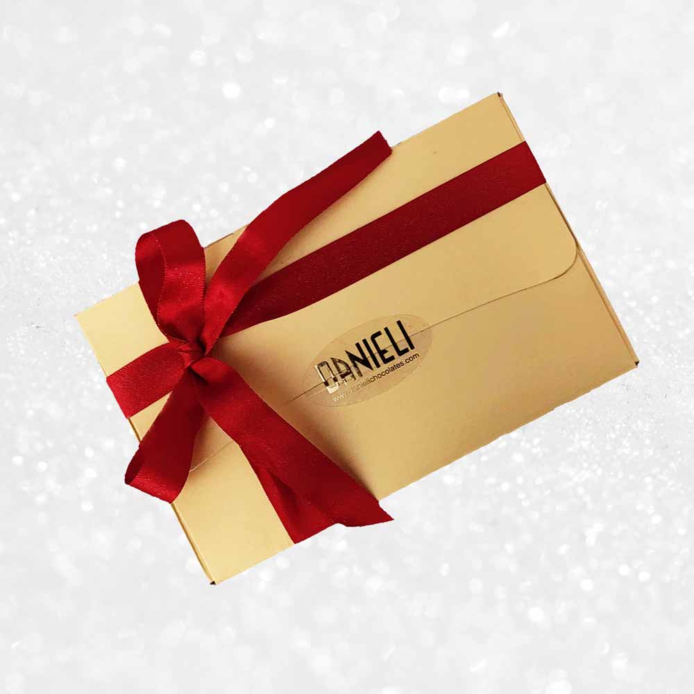 View from above of Danieli chocolates for Christmas large gold ballotin on a snowy background