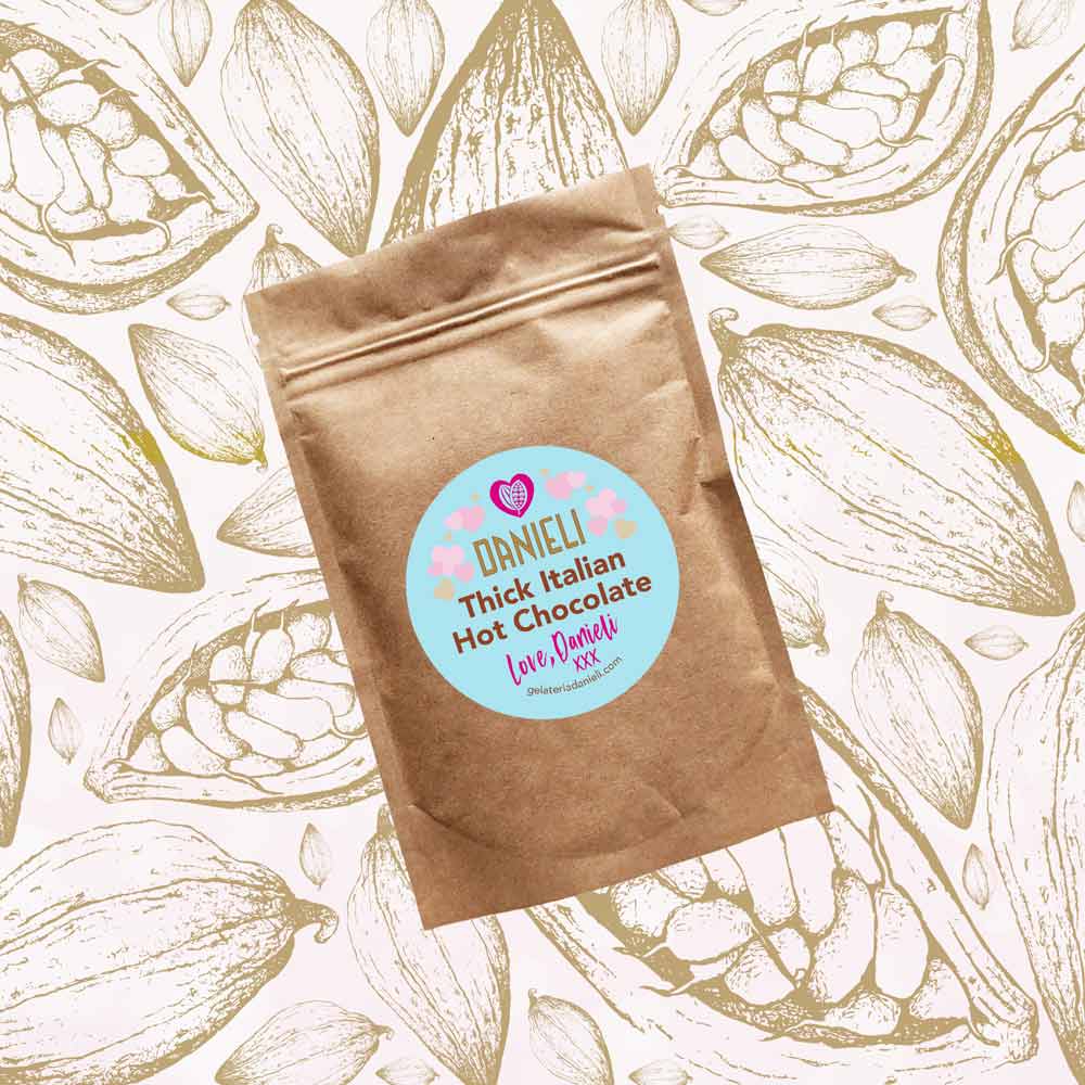 front view of Danieli luxury hot chocolate 100g pouch pink edition on a cacao background