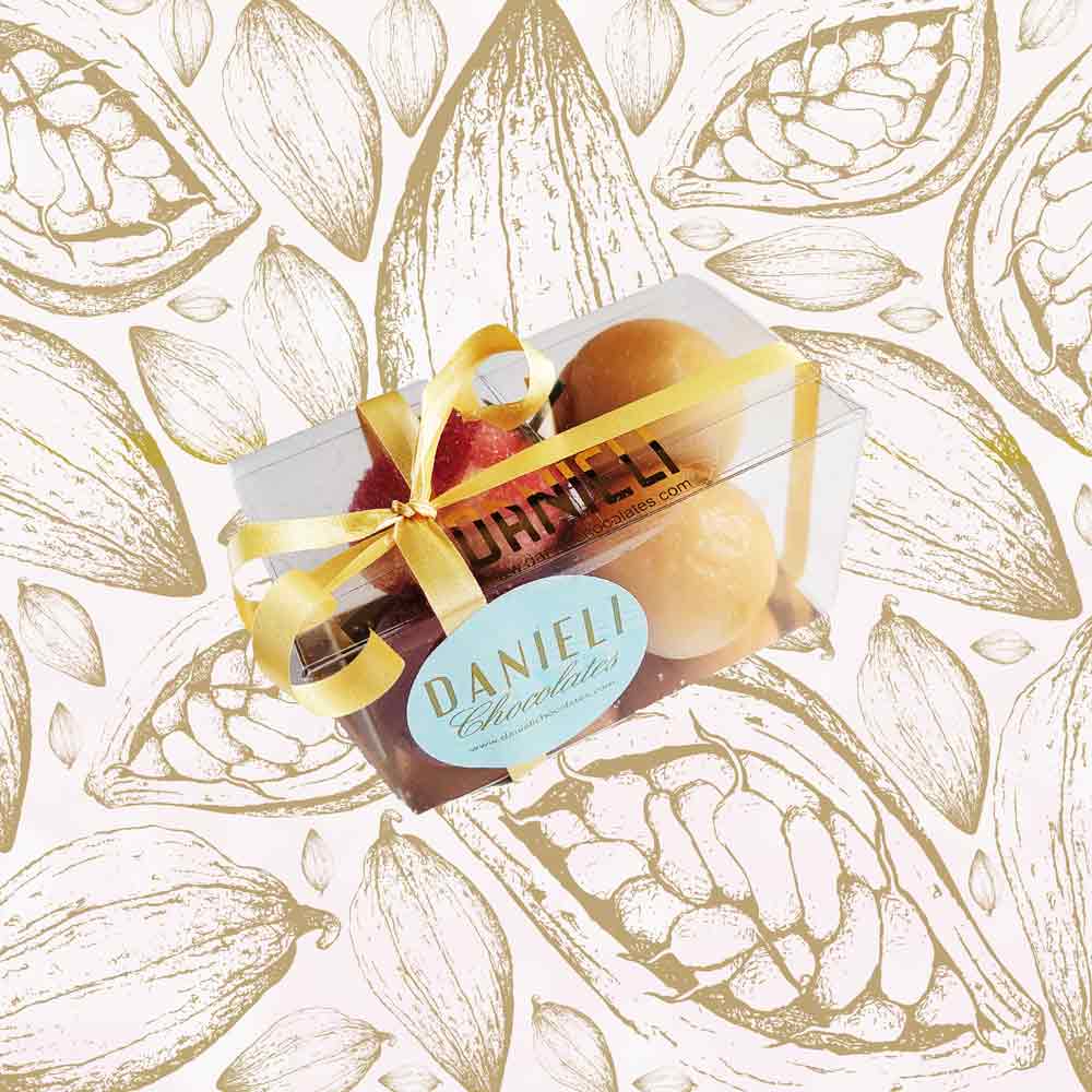 side view of a gift box of Danieli marzipan fruits on a cacao background