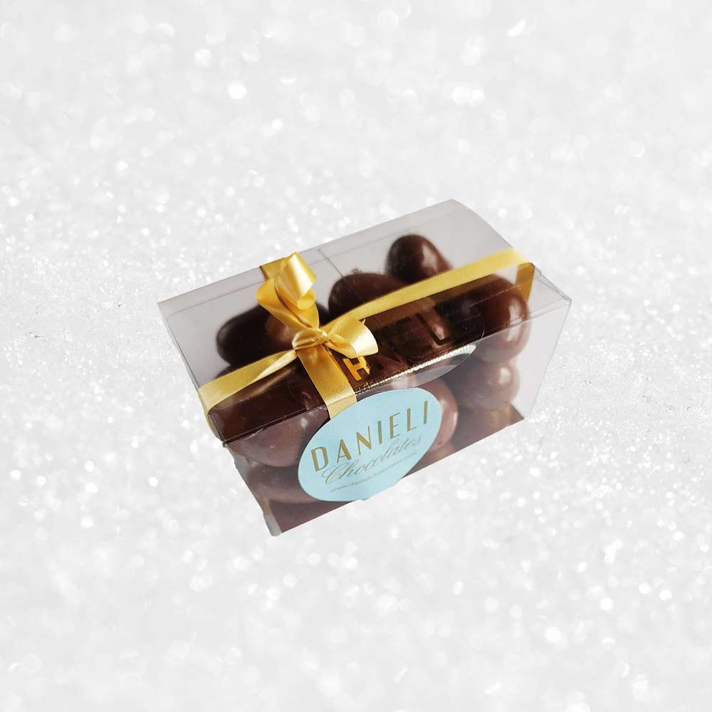 side view of a gift box of Danieli milk chocolate brazils on a snowy background