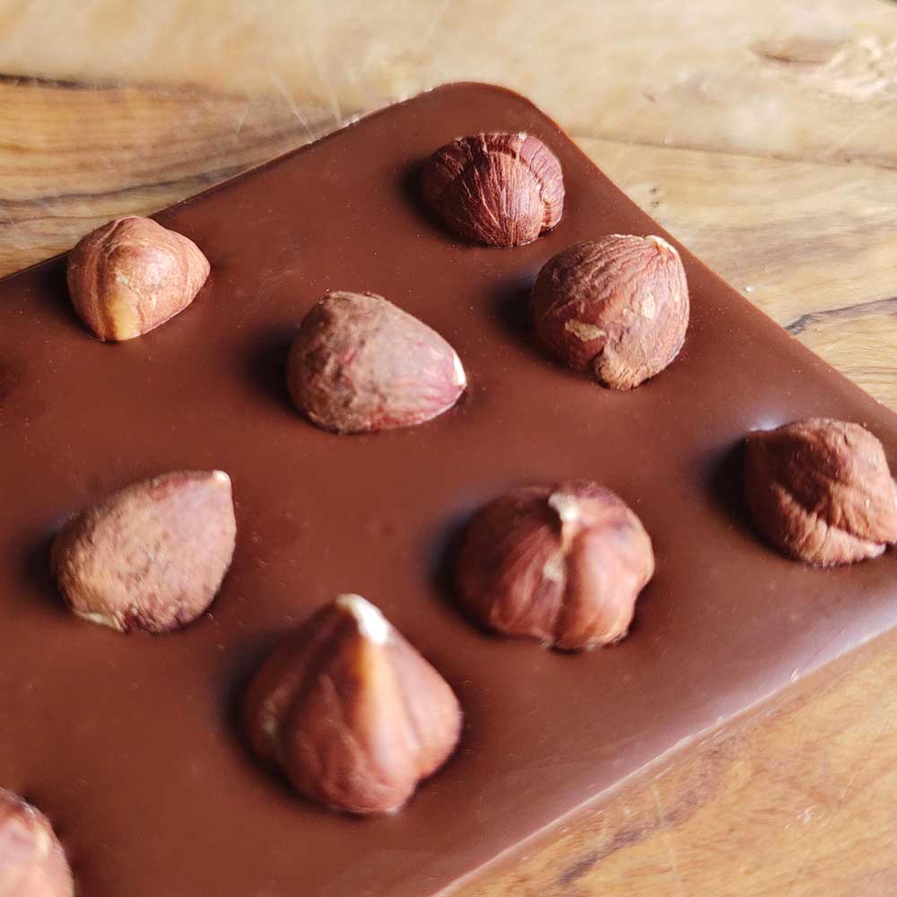 close up of Danieli milk chocolate hazelnut bar on a wooden board