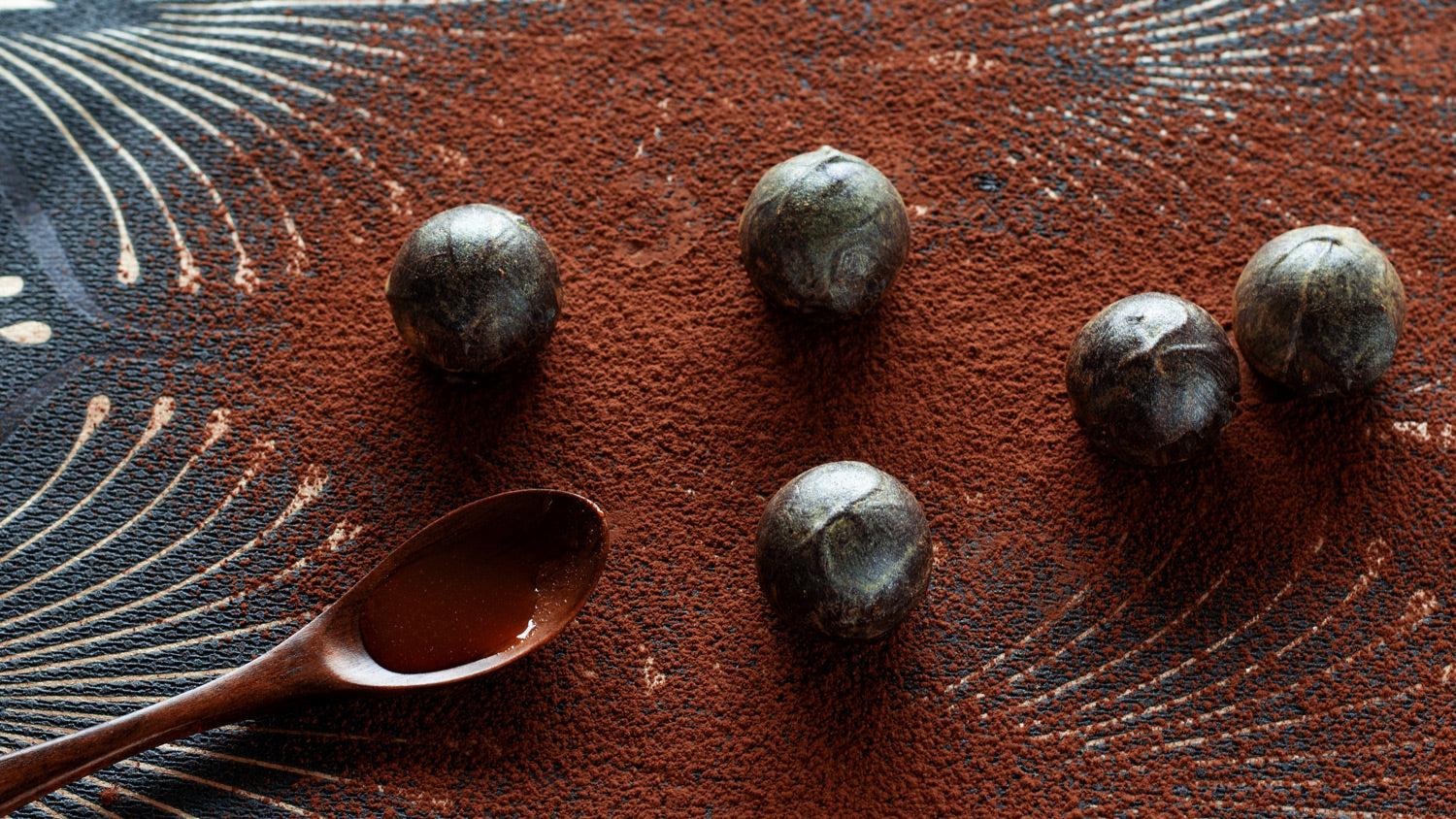Miso vegan chocolate truffles on a cocoa dusted background