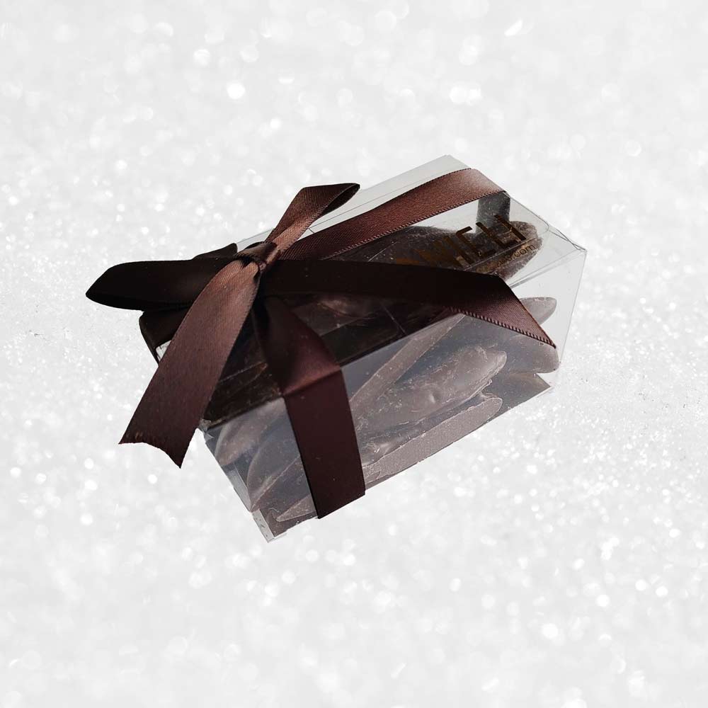 side view of a gift box of Danieli orangettes on a snowy background