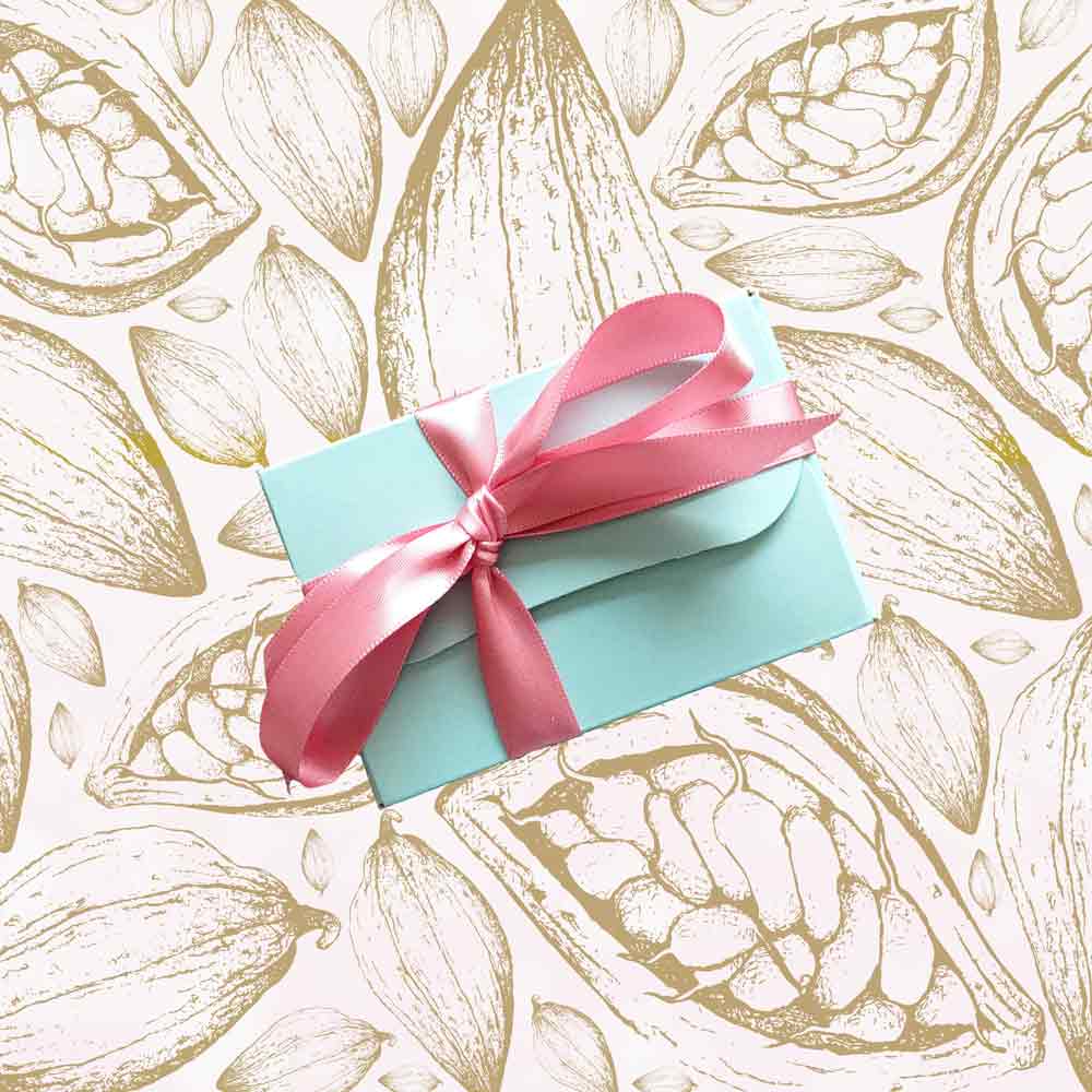 top view of a gift box of Danieli rose and violet chocolate creams on a cacao background