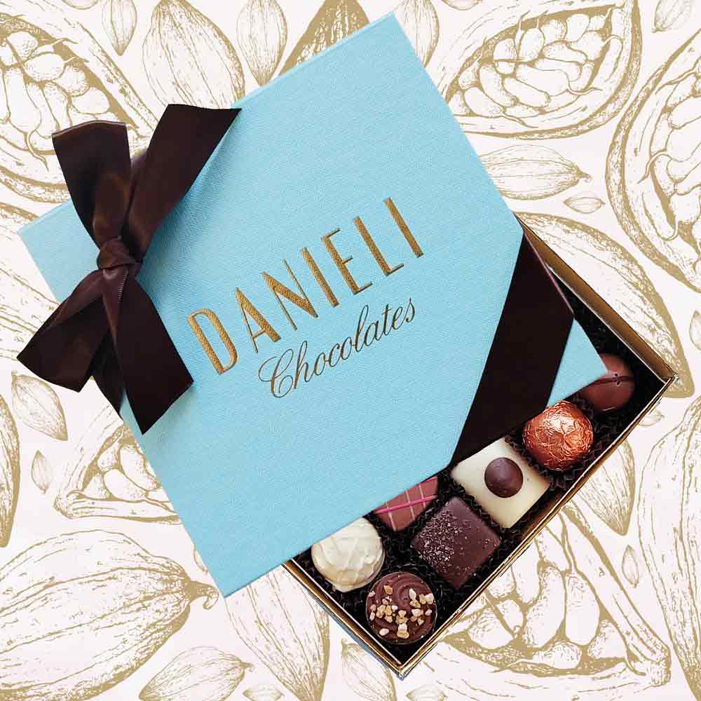 Box of chocolates with a blue Danieli Chocolates box on a decorative background
