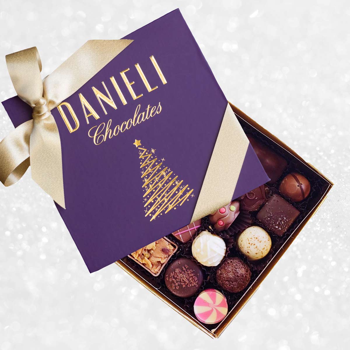 Festive purple Box of Danieli Chocolates with a gold ribbon