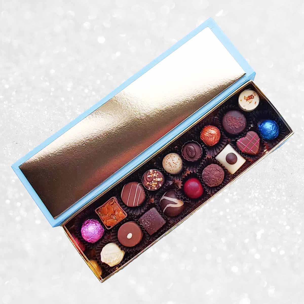 Assorted chocolates in a decorative box on a light background