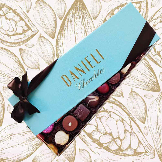 Box of Danieli Chocolates with a blue ribbon on a decorative background