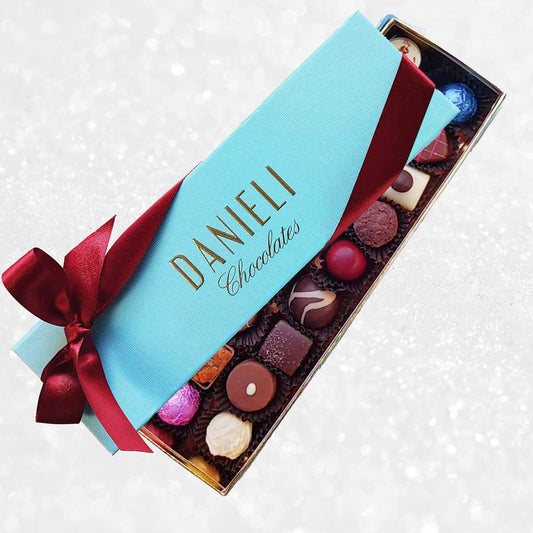 Box of Danieli Chocolates with a red ribbon on a decorative background
