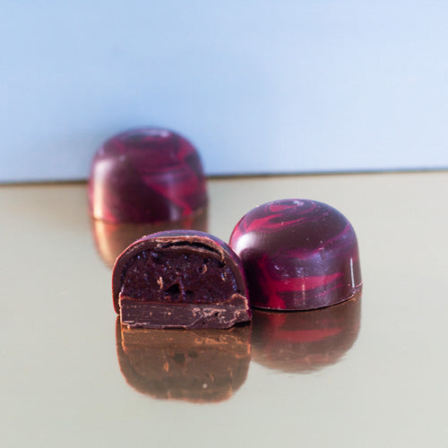 Dark cherry chocolates on a gold background