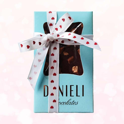 top view of gift pack of three danieli chocolate bars on a cacao background