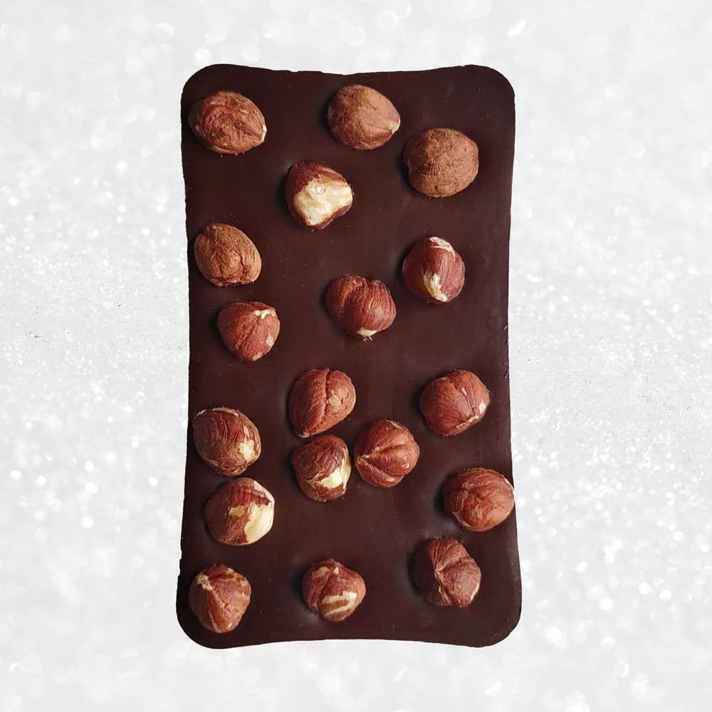 whole bar of Danieli dark chocolate hazelnut bar on a cacao background