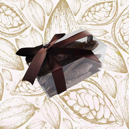 side view of a gift box of Danieli orangettes on a cacao pod background