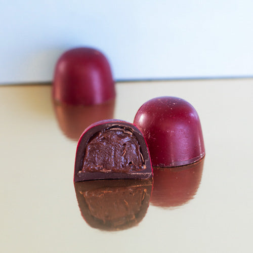 Dark chocolate cherry ganache on a gold background