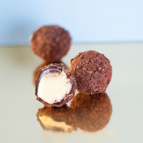 Dark chocolate champagne truffle on a gold background