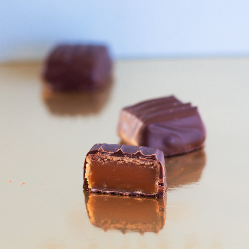 Dark chocolate chewy caramel on a gold background