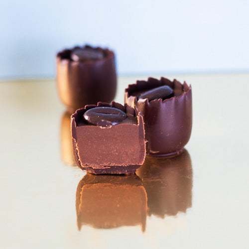 Dark chocolate coffee praline on a gold background
