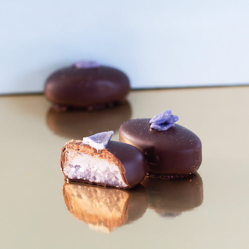 Dark chocolate violet creams on a gold background