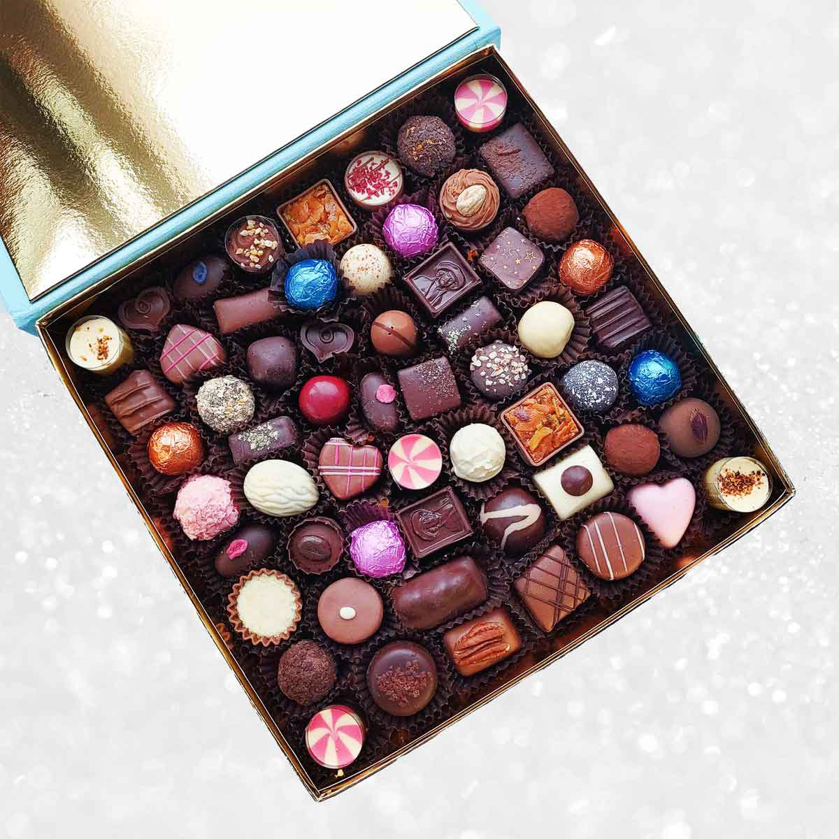 Blue box of Danieli Chocolates with a brown ribbon on a decorative background