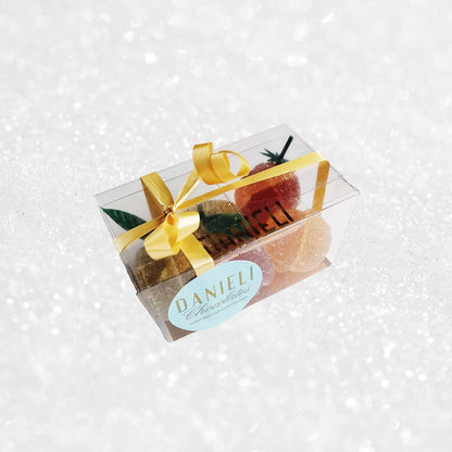 side view of a presentation box of Danieli fruit jellies on a snowy background