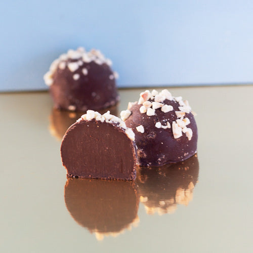 Hazelnut dark chocolate truffle on a gold background