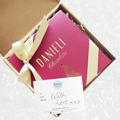 delivery box view of Danieli chocolates for Christmas luxury red box large with a gold ribbon on a snowy background