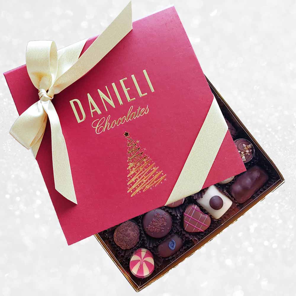 top view of Danieli chocolates for Christmas luxury red box large with a gold ribbon on a snowy background