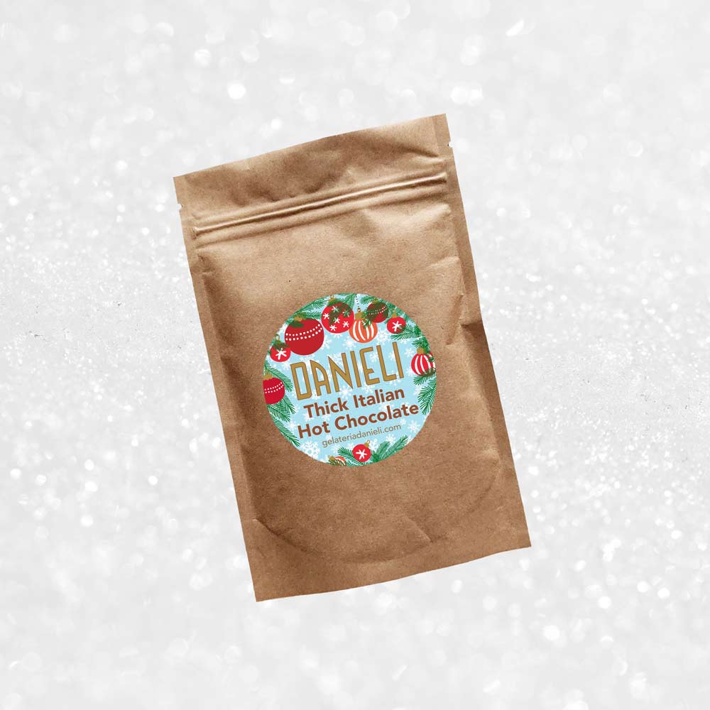 front view of Danieli luxury hot chocolate 100g pouch festive edition on a snowy background