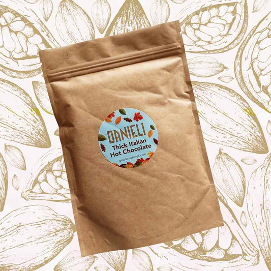 front view of Danieli luxury hot chocolate 300g pouch autumn edition on a cacao pod background