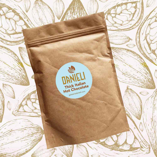 front view of Danieli luxury hot chocolate 300g pouch classic edition on a cacao pod background