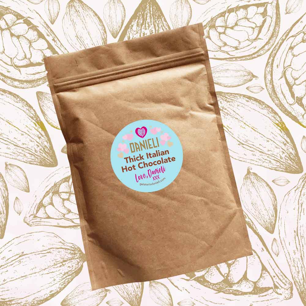 front view of Danieli luxury hot chocolate 300g pouch pink edition on a cacao background