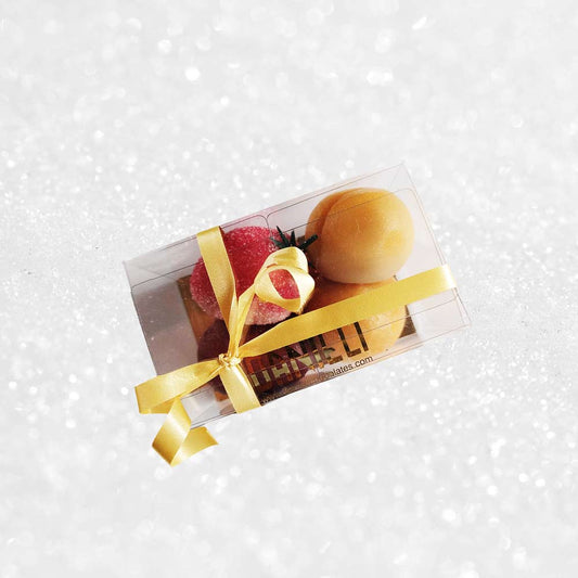 side view of a gift box of Danieli marzipan fruits on a snowy background