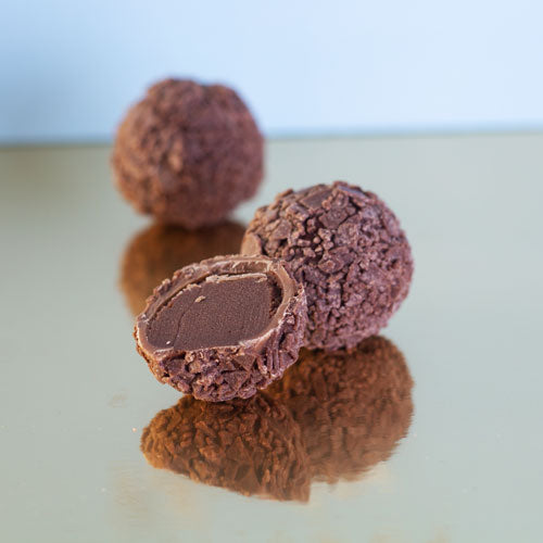 Milk chocolate truffle on a gold background