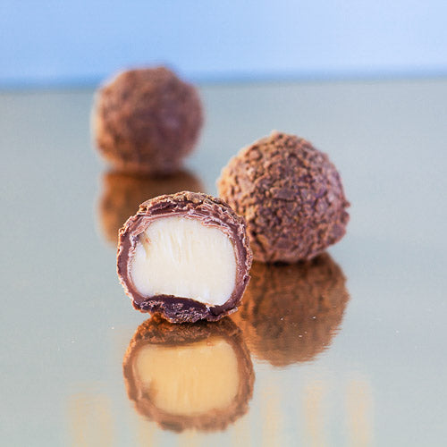 Milk chocolate champagne truffle on a gold background