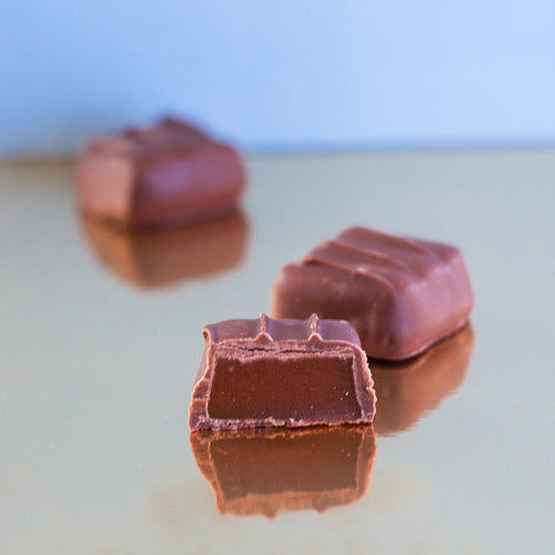 Milk chocolate chewy caramel on a gold background