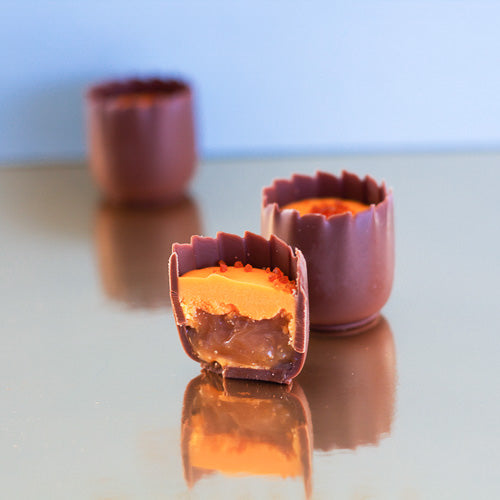 Milk chocolate mango cup on a gold background