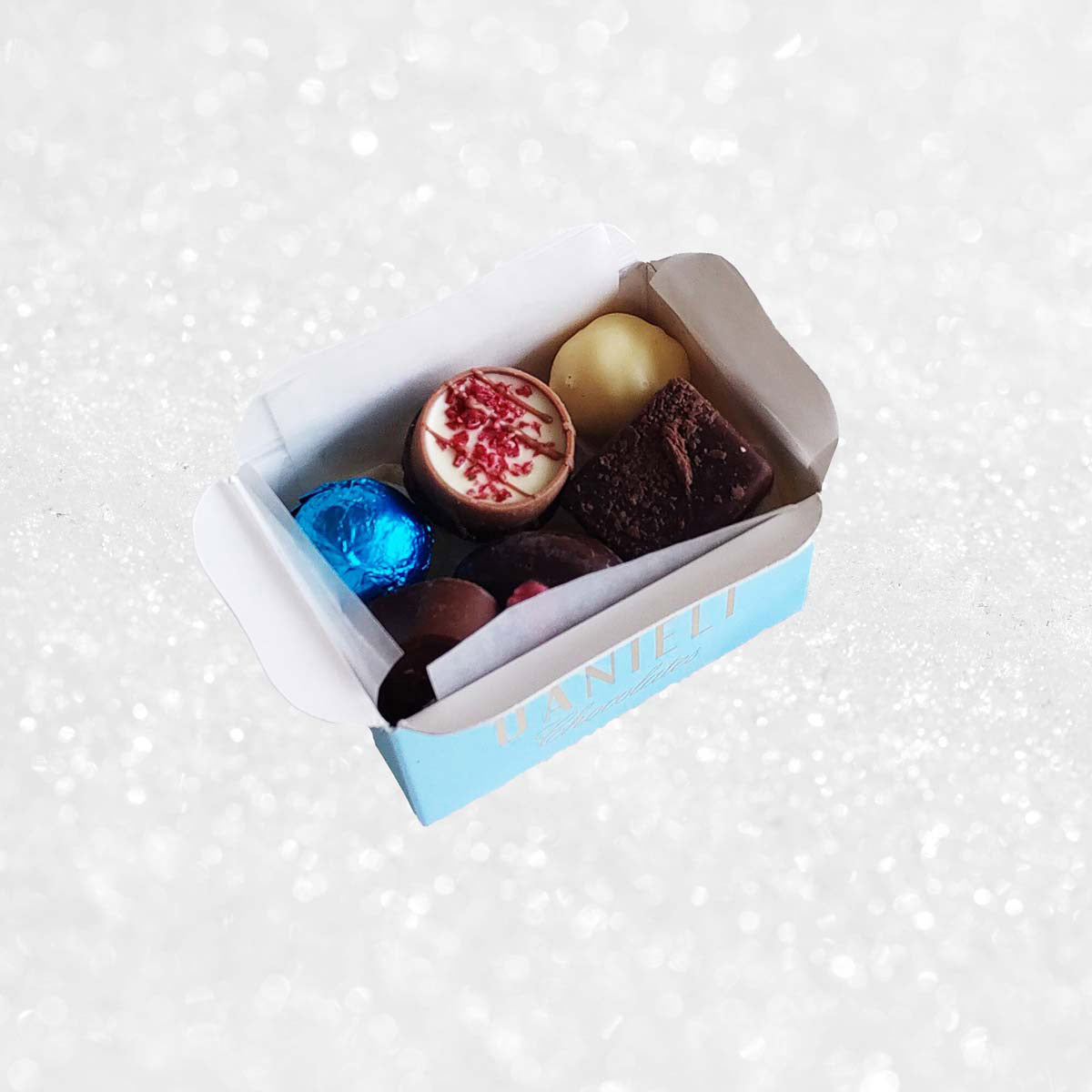 Assorted colorful chocolates in a box on a white background