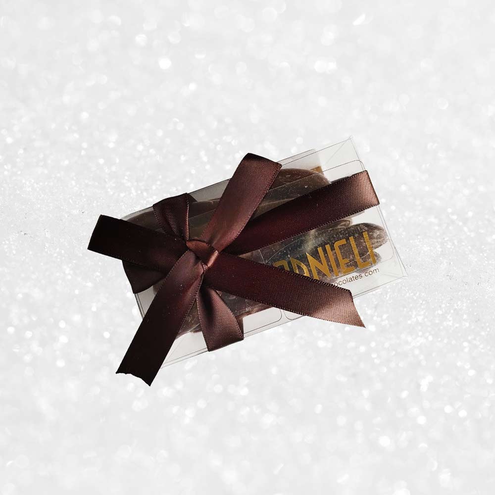 top view of a gift box of Danieli orangettes on a snowy background