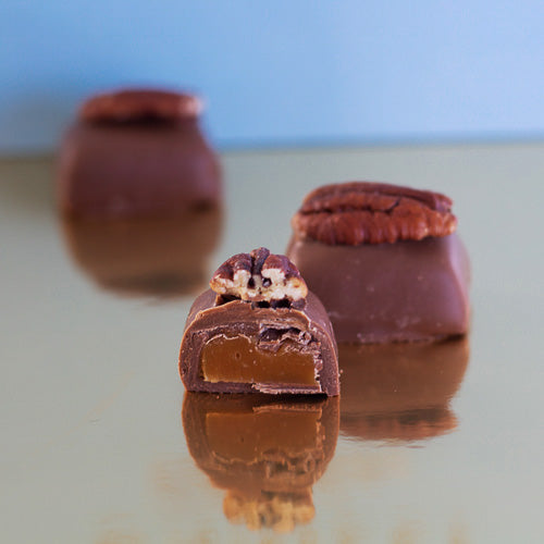 Pecan and maple milk chocolate on a gold background