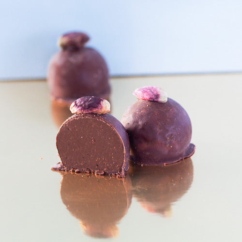 Pistachio dark chocolate truffle on a gold background