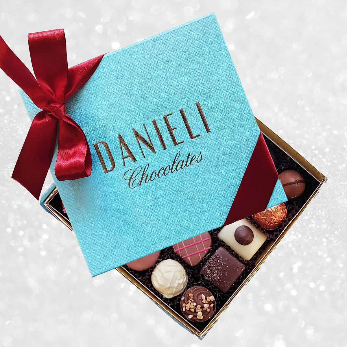 Box of chocolates with a blue Danieli Chocolates box on a decorative background