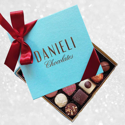 Box of chocolates with a blue Danieli Chocolates box on a decorative background